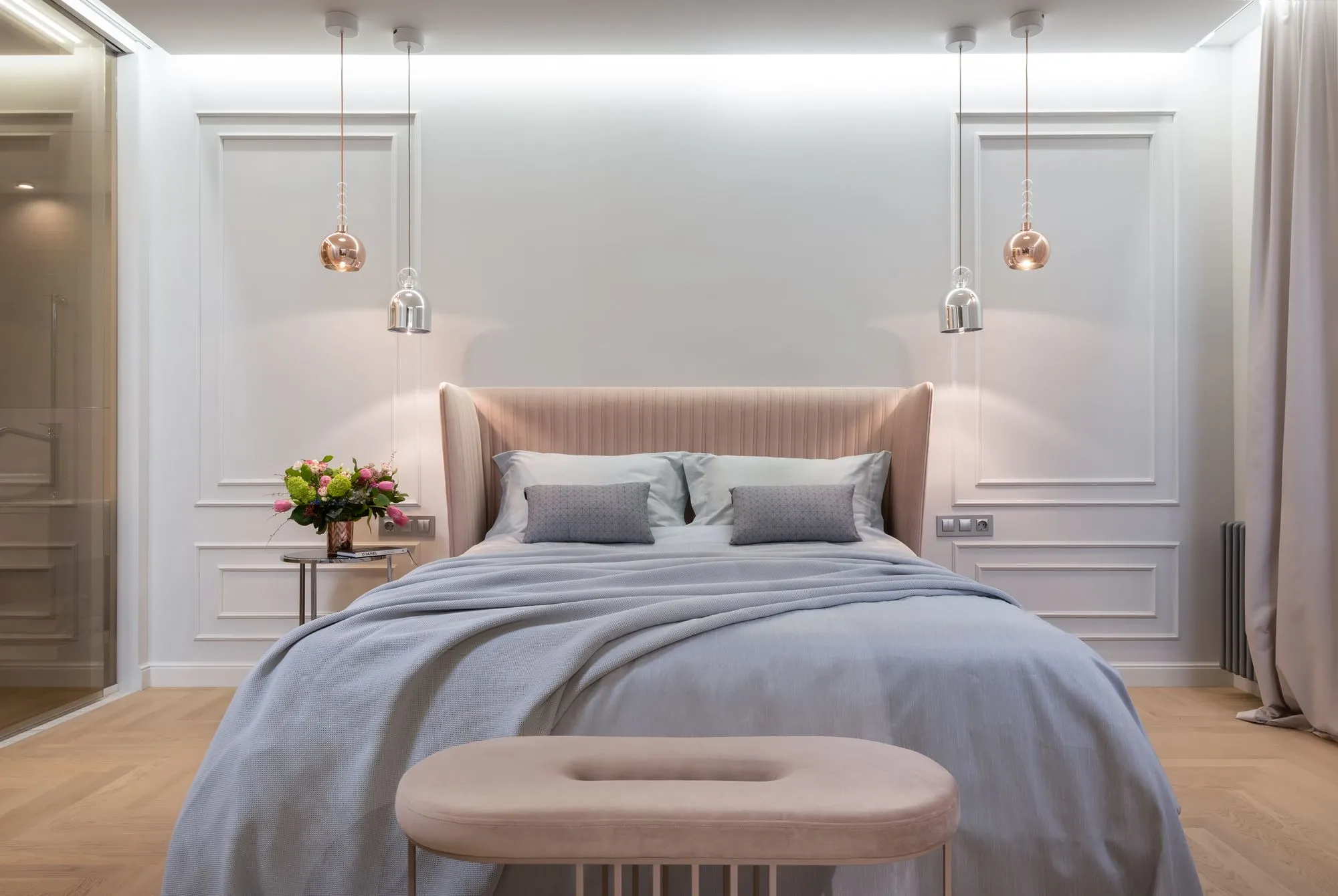 A pale, minimal bedroom with soft light